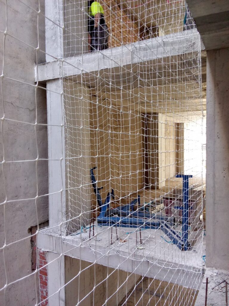 Redes de seguridad verticales cerrando los huecos de forjado de un edificio en obra